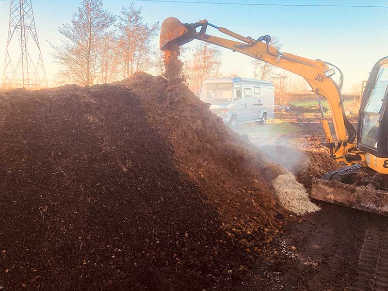 mixing large pile of compost